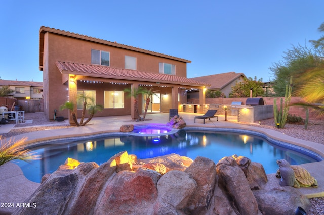 pool at dusk featuring an in ground hot tub, area for grilling, and a patio area