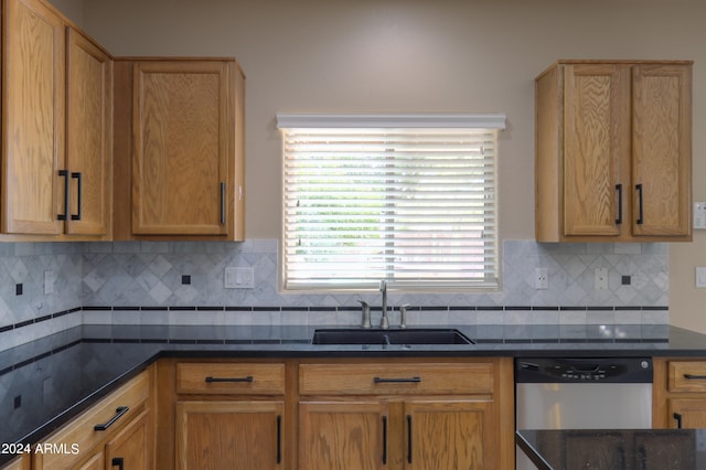 kitchen with stainless steel dishwasher, sink, and tasteful backsplash