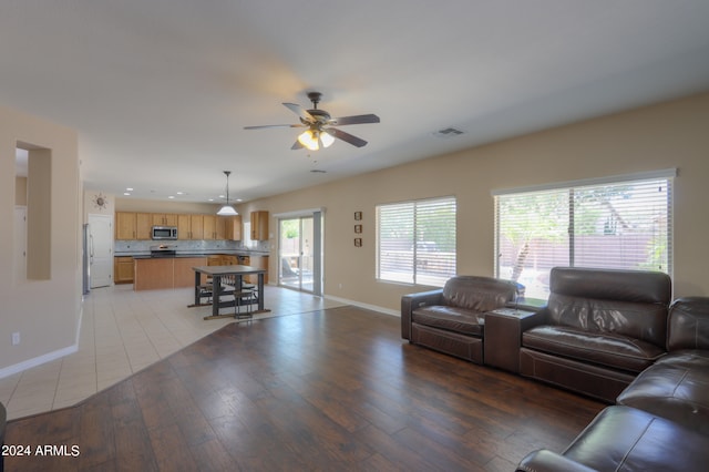 living room featuring light hardwood / wood-style flooring and ceiling fan