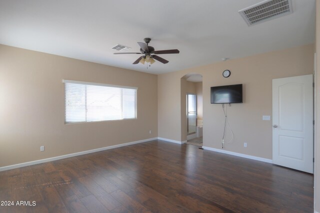 bedroom with dark hardwood / wood-style flooring, ceiling fan, and a walk in closet