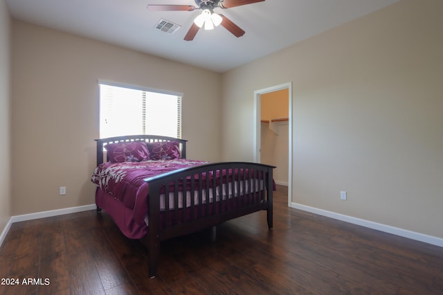 bedroom with ceiling fan, a closet, dark hardwood / wood-style flooring, and a spacious closet