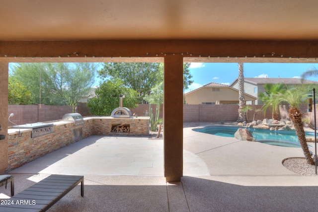 exterior space with grilling area, an outdoor kitchen, and a patio area