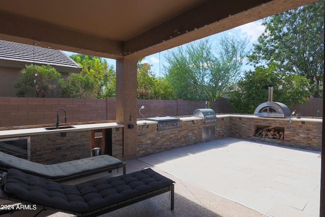 view of patio with an outdoor kitchen and sink