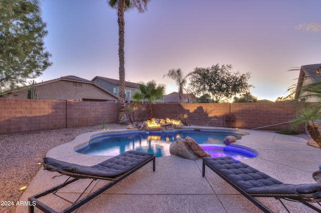 pool at dusk with a patio area