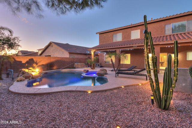 pool at dusk featuring a patio