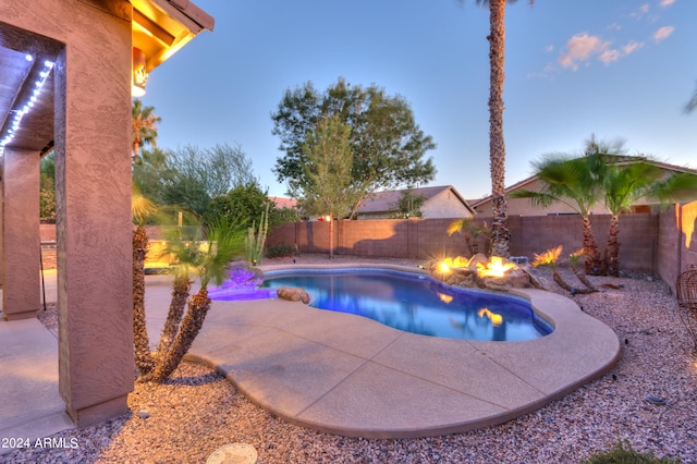 pool at dusk with a patio