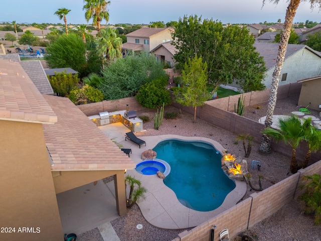 view of swimming pool featuring an in ground hot tub, a patio, and an outdoor fire pit