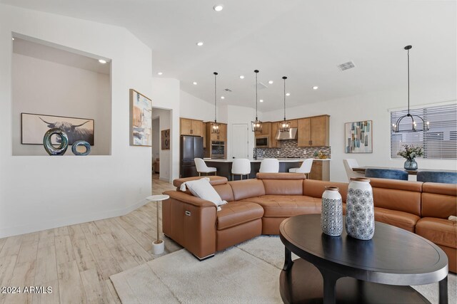 living room with light hardwood / wood-style floors and vaulted ceiling