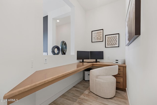 office with light hardwood / wood-style flooring and built in desk