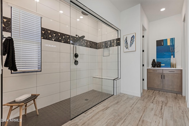 bathroom with wood-type flooring and a tile shower