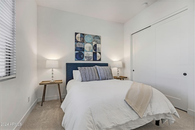 bedroom with light carpet and a closet