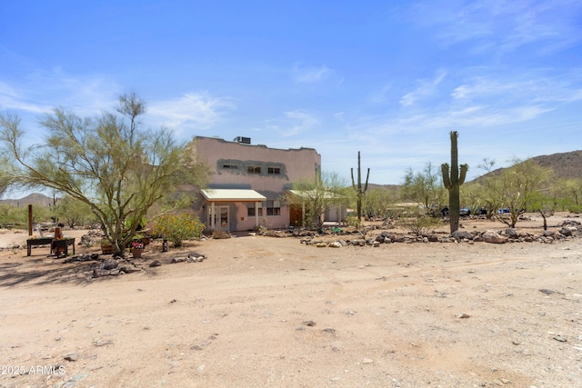 40834 N 26th St, Cave Creek, AZ 85331 - rear view of house featuring a mountain view, stucco siding, metal roof, and a view of rural / pastoral area
