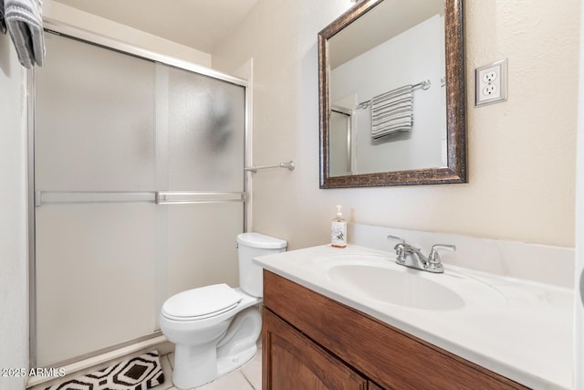 bathroom featuring walk in shower, tile patterned floors, vanity, and toilet