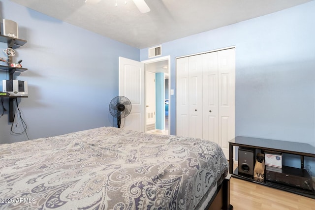 bedroom featuring light hardwood / wood-style flooring, ceiling fan, and a closet