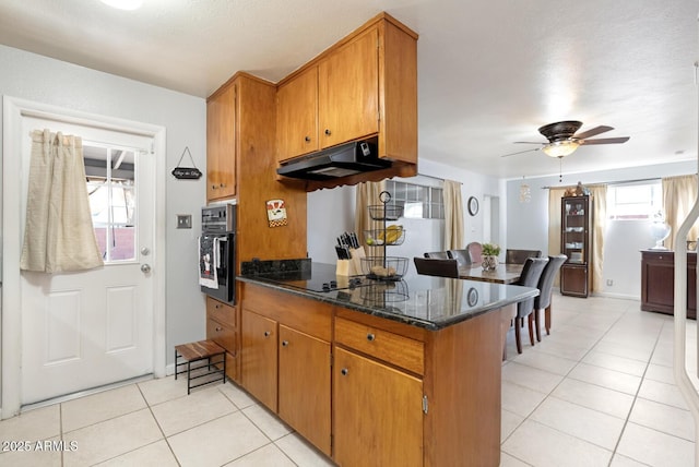 kitchen with ceiling fan, dark stone counters, a textured ceiling, and black appliances