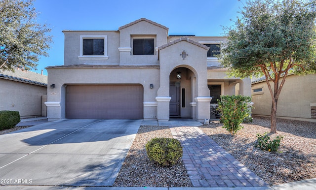 view of front facade featuring a garage, concrete driveway, a tile roof, and stucco siding