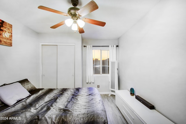 bedroom featuring light hardwood / wood-style flooring, a closet, and ceiling fan