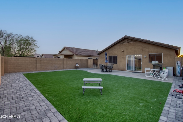 rear view of property with a yard and a patio area