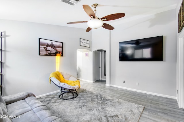 living room featuring ceiling fan, wood-type flooring, and vaulted ceiling