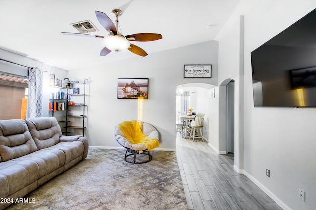 living room with ceiling fan, vaulted ceiling, and hardwood / wood-style floors