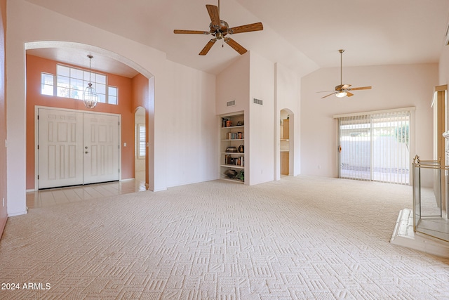 carpeted entrance foyer with ceiling fan and high vaulted ceiling