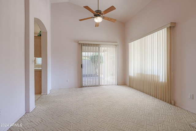 spare room with ceiling fan, light carpet, and high vaulted ceiling