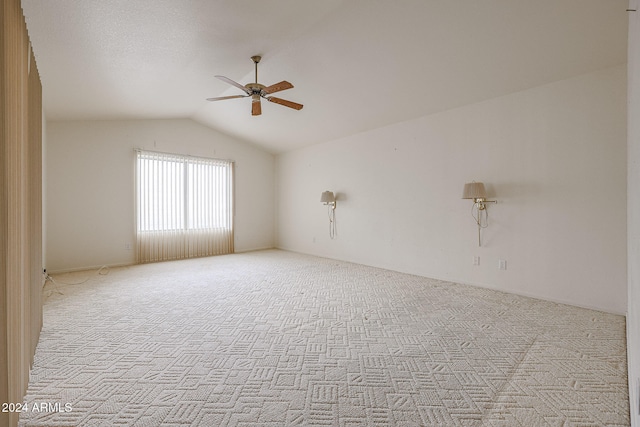 carpeted spare room featuring ceiling fan and lofted ceiling