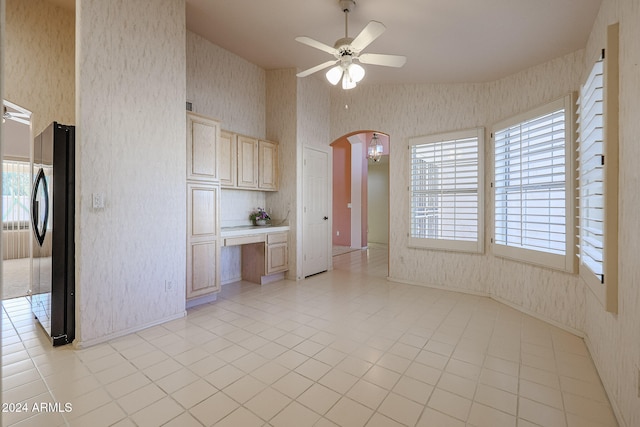 kitchen featuring ceiling fan, light brown cabinets, stainless steel fridge, light tile patterned flooring, and built in desk