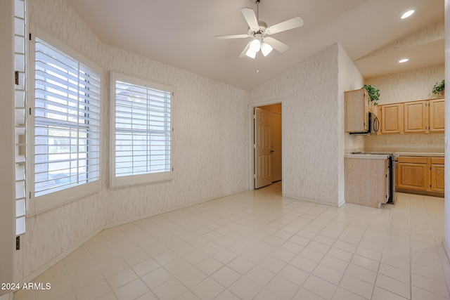 interior space featuring a healthy amount of sunlight, lofted ceiling, stainless steel appliances, and light brown cabinets