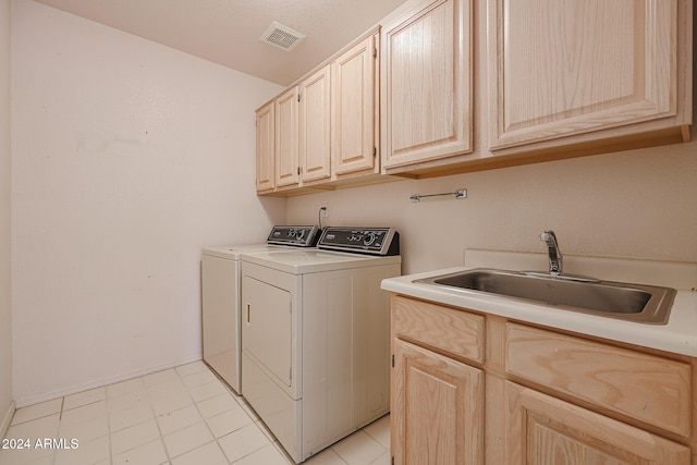 laundry room with separate washer and dryer, sink, light tile patterned floors, and cabinets