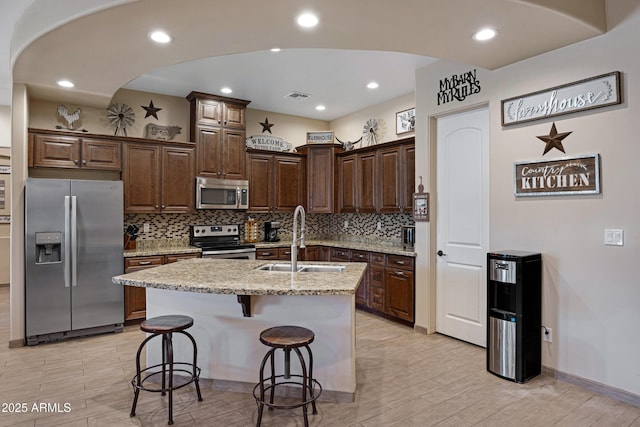 1008 E Mano Dr, New River, AZ 85087 - kitchen with stainless steel appliances, a sink, backsplash, light stone counters, and recessed lighting
