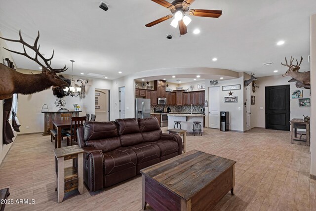 1008 E Mano Dr, New River, AZ 85087 - living room with recessed lighting, a ceiling fan, arched walkways, light wood-style flooring, and baseboards