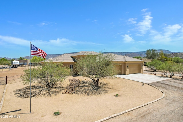 1008 E Mano Dr, New River, AZ 85087 - view of property hidden behind natural elements with driveway, an attached garage, a mountain view, and stucco siding