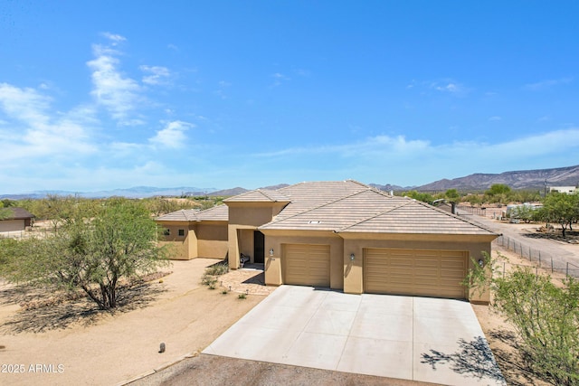 1008 E Mano Dr, New River, AZ 85087 - prairie-style home featuring an attached garage, stucco siding, driveway, a mountain view, and a tile roof