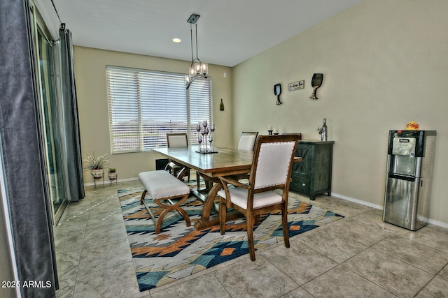 dining room featuring a notable chandelier, tile patterned flooring, and baseboards