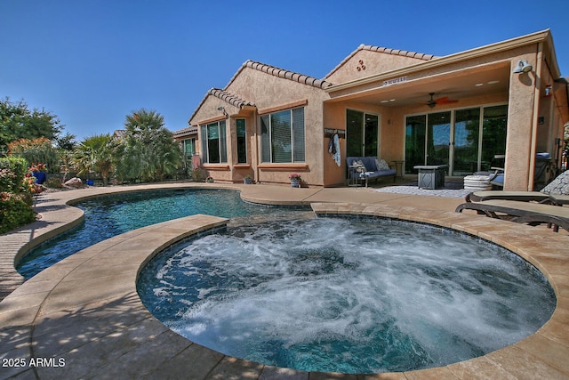 outdoor pool featuring a patio area, ceiling fan, and an in ground hot tub