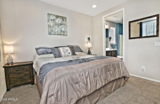 carpeted bedroom featuring connected bathroom and baseboards