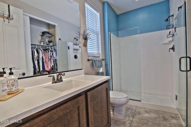 full bathroom with a stall shower, tile patterned flooring, vanity, and toilet