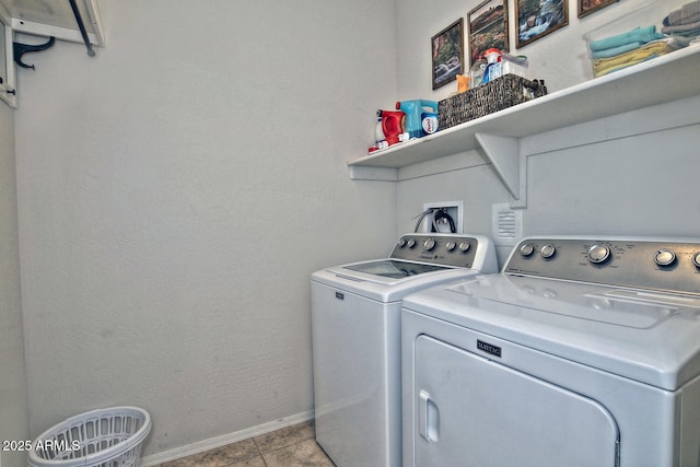 washroom featuring laundry area, washer and clothes dryer, baseboards, and tile patterned floors