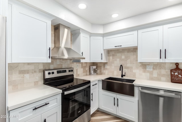 kitchen with white cabinets, sink, wall chimney exhaust hood, and appliances with stainless steel finishes