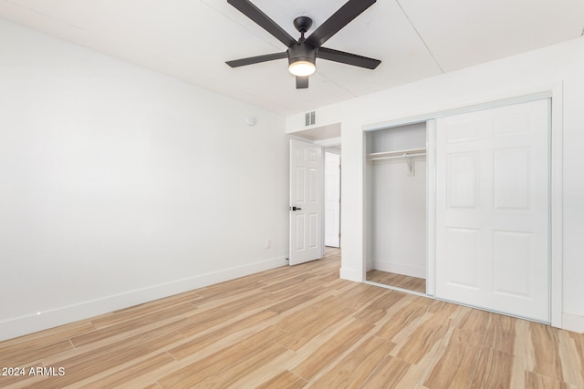 unfurnished bedroom featuring a closet, light hardwood / wood-style floors, and ceiling fan