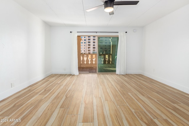 empty room with ceiling fan and light hardwood / wood-style flooring