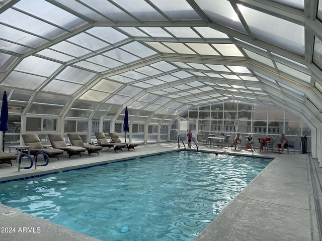 view of swimming pool with a patio area and a lanai