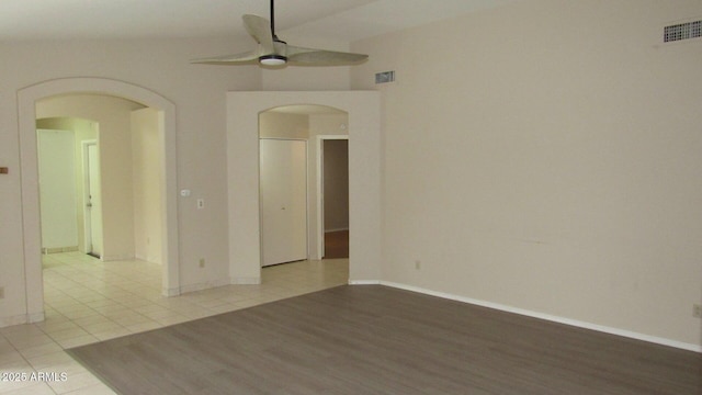 spare room with a ceiling fan, visible vents, arched walkways, and tile patterned flooring