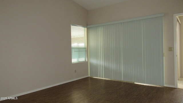 unfurnished room featuring baseboards and dark wood-style flooring