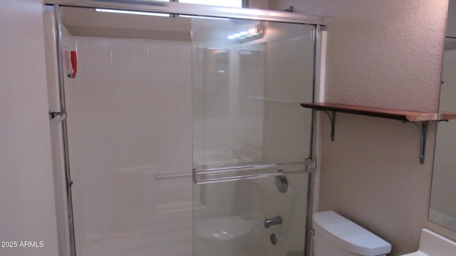 bathroom featuring an enclosed shower, toilet, and a textured wall
