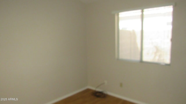 empty room with wood finished floors and baseboards
