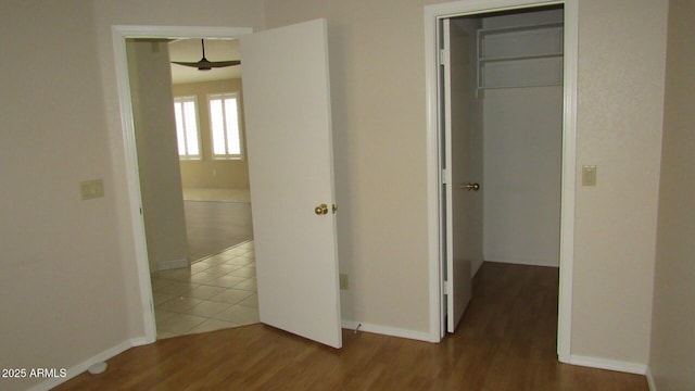 hallway with baseboards and wood finished floors