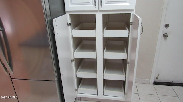 interior details with white cabinetry and freestanding refrigerator