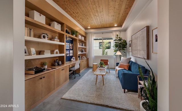 living area with built in desk, built in features, wood ceiling, and a raised ceiling